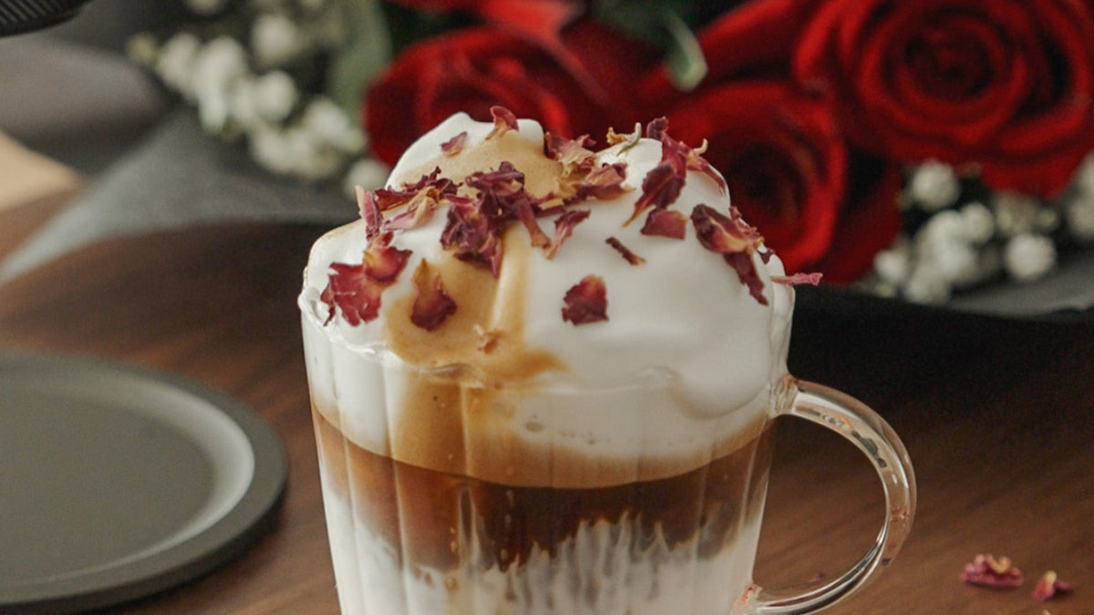 Nahaufnahme eines geschichteten Kaffeespezialgetränks in einer gerippten Glastasse