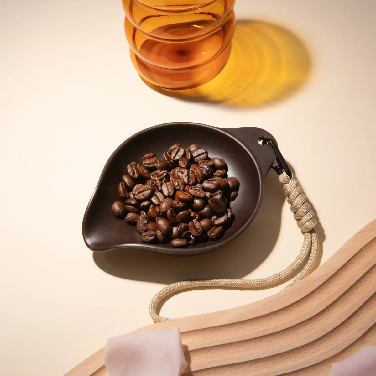 Dunkelbraunes OutIn Rebrew Bohnen-Tablett mit Kaffee Bohnen und beigefarbenem Lanyard für Produktanzeige.