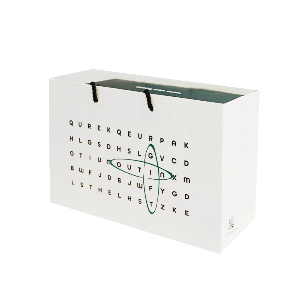 Weiße Geschenktasche mit Wortsuchrätsel-Design und Kordelgriffen, ideal für tragbare Espressomaschinen.