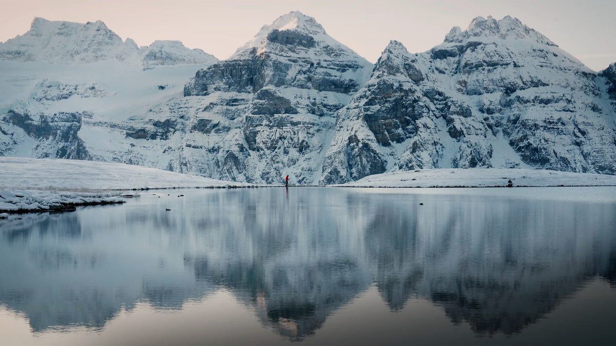 Spiegelung schneebedeckter Berge im ruhigen See, friedliche Winterlandschaft im Banff-Nationalpark﻿