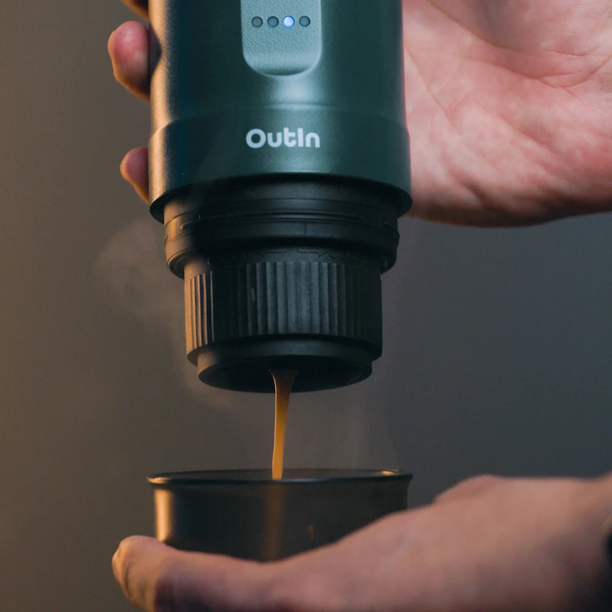 Nano tragbare Espressomaschine blaugrün in Benutzung: Espresso fließt dampfend in eine Tasse.