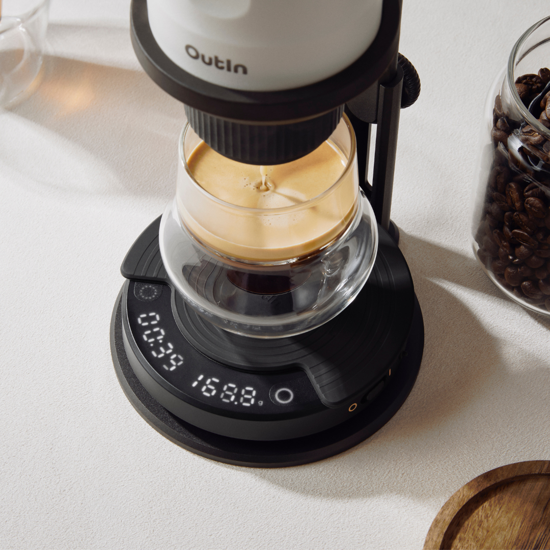 Schwarze OutIn Claro Kaffeewaage beim Espresso-Brühen mit Timer (00:39) und Gewicht (168.8g) Anzeige, daneben Kaffeebohnen.